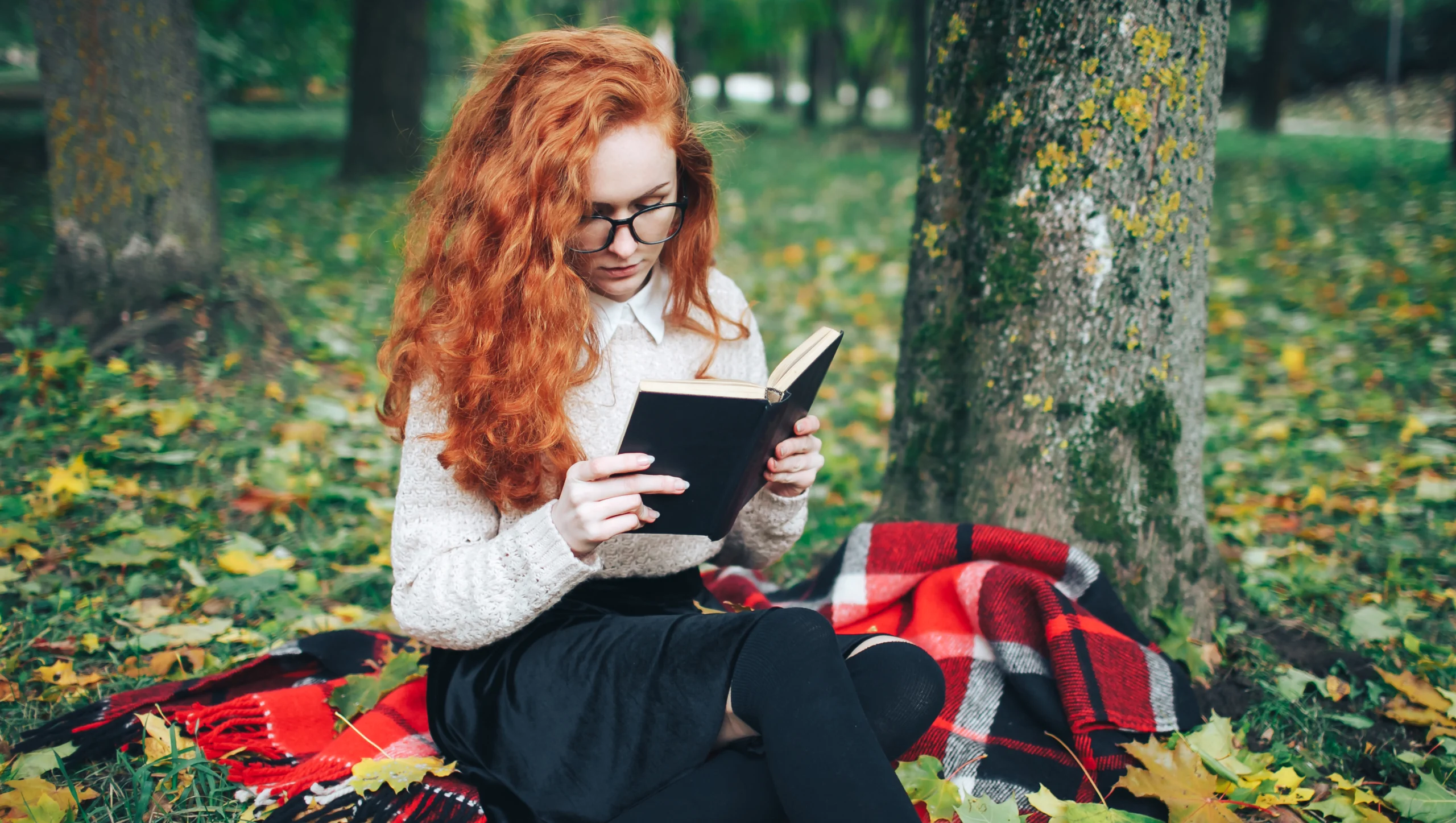 redhead girl reading book autumn park scaled redhead girl reading book autumn park scaled